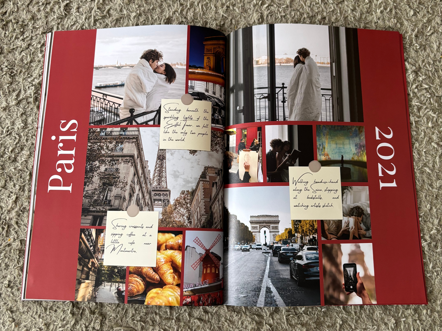An open printed photo album or collage book laid flat on a textured beige carpet. The pages feature red side panels with the words 'Paris' and '2021', multiple travel-themed photos, handwritten note overlays, and small food and city scenes.